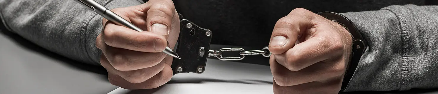 Man in handcuffs awaits criminal charges that could lead to deportation for a crime he committed in the United States